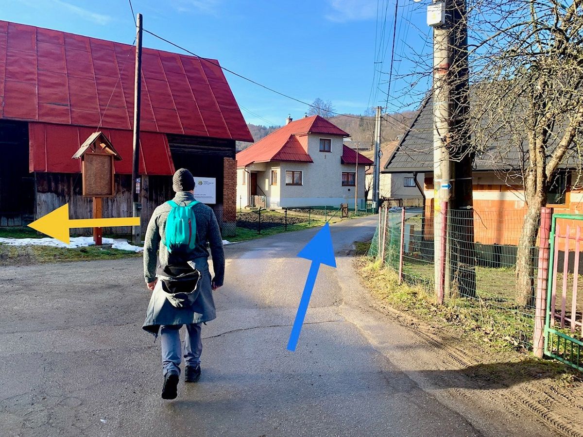 Časť trasy po modrej turistickej značke prechádza cez obec. Ak by ste v tomto úseku odbočili doľava (ako ukazuje žltá značka), tiež by ste sa po hlavnej ceste dostali až ku zvonici. My sme si vybrali o čosi náročnejší výstup.