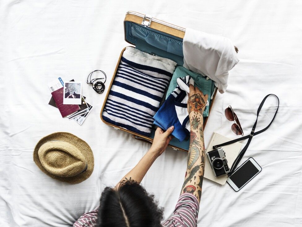 aerial-view-man-packing-clothes-trip.jpg