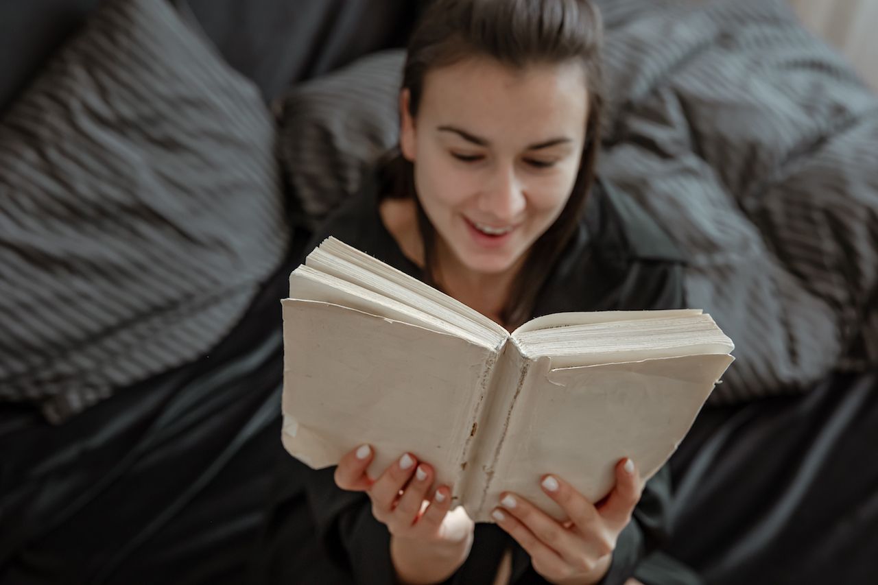 attractive-young-woman-pajamas-is-relaxing-bed-while-reading-book.jpg