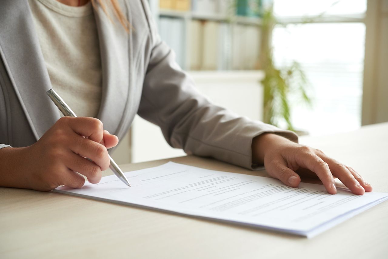 cropped-mid-section-unrecognizable-woman-signing-document.jpg