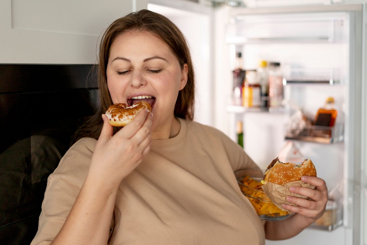 person-with-eating-disorder-trying-eat-fast-food.jpg