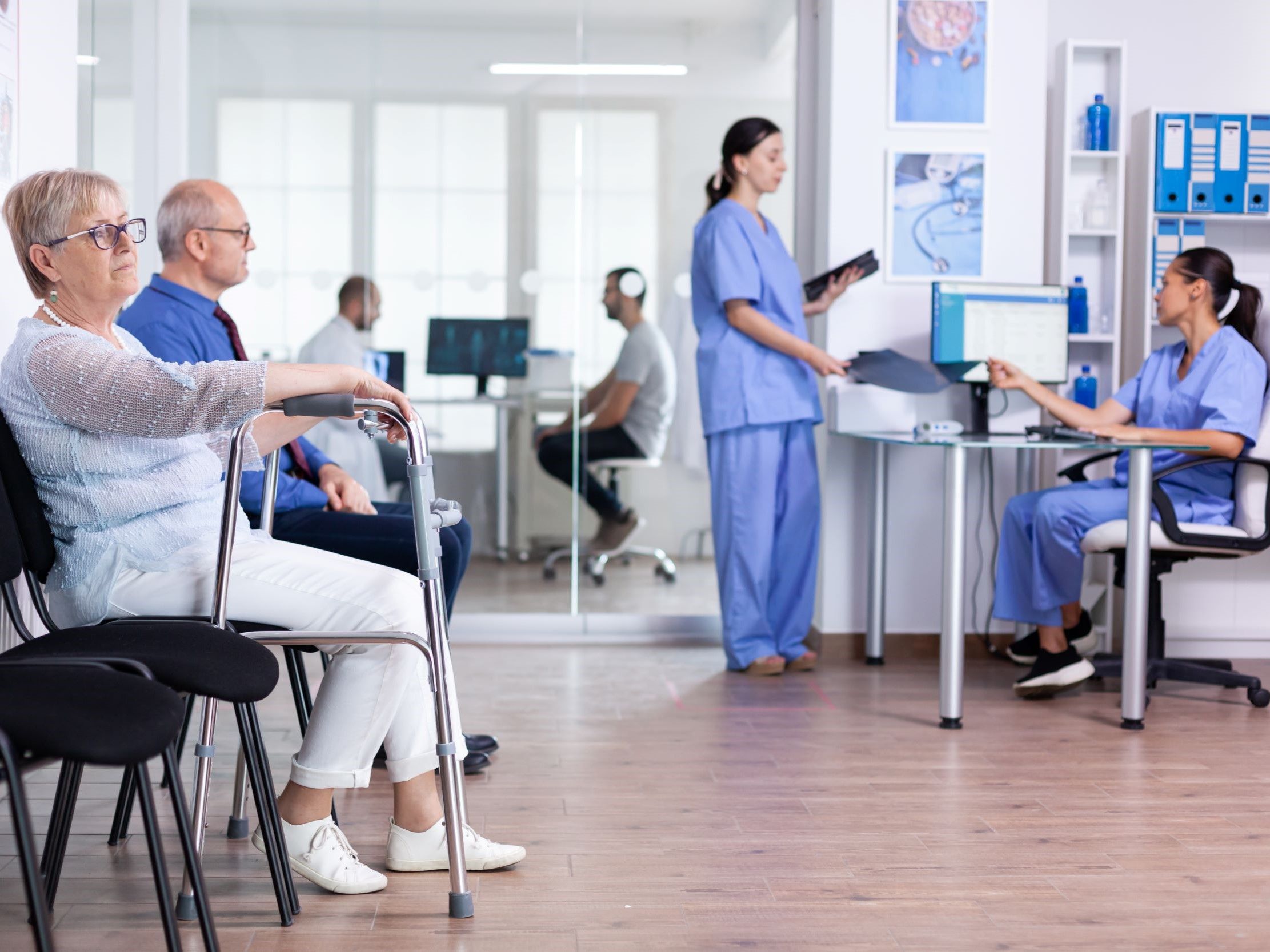 senior-woman-with-walking-frame-hospital-waiting-room-rehabilitation-treatment.jpg