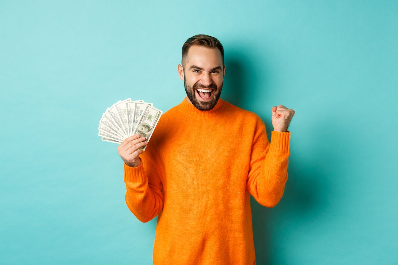 shopping-cheerful-guy-holding-money-winning-prize-cash-making-fist-pump-triumphing.jpg