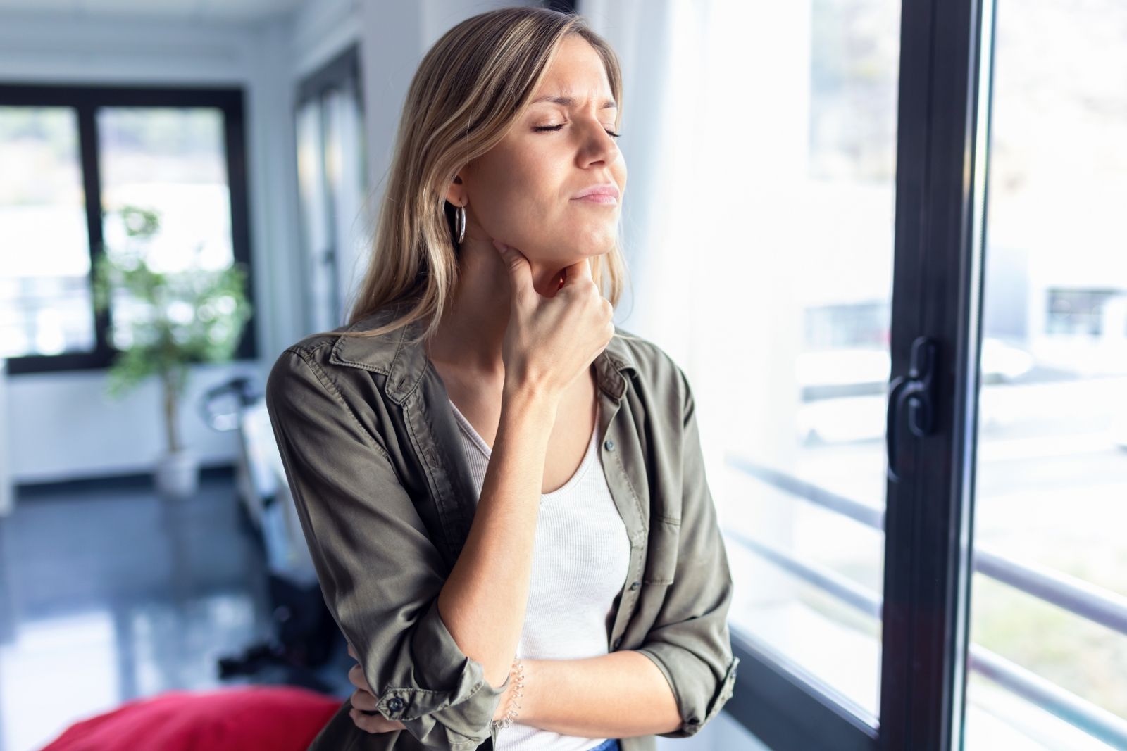 shot-illness-young-woman-with-terrible-throat-pain-while-standing-living-room-home_1600x1067.jpg