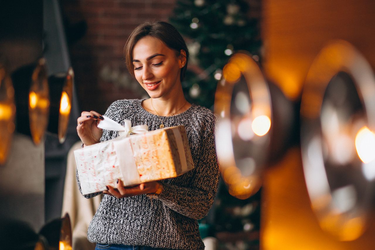 woman-with-presents-front-christmas-tree.jpg