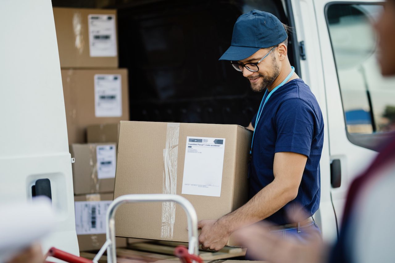 young-manual-worker-unloading-cardboard-boxes-from-delivery-van.jpg